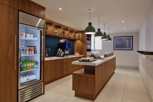 a kitchen with a refrigerator with drinks in it at Delta Hotels by Marriott Chicago Willowbrook in Willowbrook