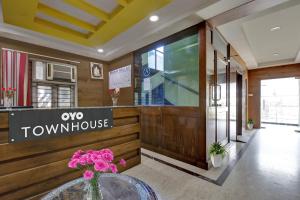 a lobby of a town house with a vase of flowers at Capital O Jayam Residency in Chennai