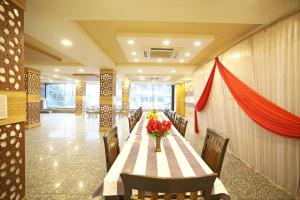 un comedor con una mesa con flores. en OYO Hotel Shanti Palace en Sikandra