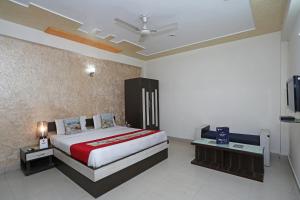 a bedroom with a large bed and a tv at OYO Hotel Shanti Palace in Sikandra