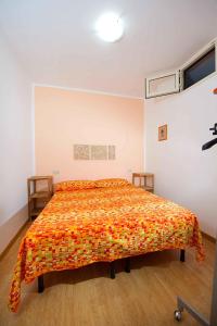 um quarto com uma cama com uma colcha laranja em Casa Vacanza Luigi em Castellammare del Golfo