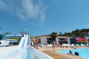 a group of people playing on a water slide at a pool at Camping Saint Georges d'Oléron in Saint-Georges-dʼOléron