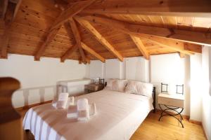 a bedroom with a large white bed with wooden ceilings at Seaside Gialova in Pylos