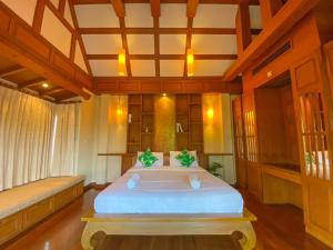 a bedroom with a large white bed in a room at Villano Lilawadee Pool Villa in Na Jomtien