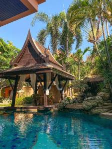 a resort with a swimming pool and a house at Villano Lilawadee Pool Villa in Na Jomtien