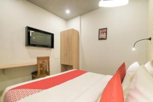 a bedroom with a bed and a flat screen tv at Collection O Jps Grand Hotel Near Dwarka Metro Station in New Delhi