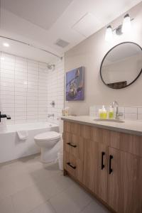 Basecamp Suites Banff في بانف: حمام مع مرحاض بالوعة ومرآة