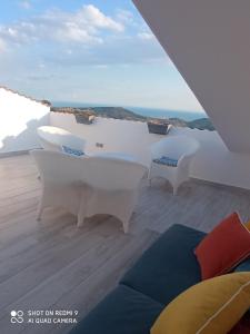a room with white furniture and a view of the ocean at Casa Belvedere in Agrigento
