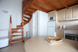 a kitchen with a table and a spiral staircase at Seaside Gialova in Pylos