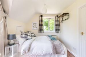 a bedroom with a bed and a window at The Lodge at Alderfen View in Neatishead