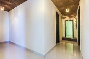 a hallway with white walls and a green door at Super Townhouse 83601 Hotel Marina in Rānchī