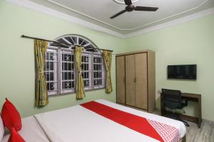 a bedroom with a bed and a tv and a window at OYO Ma Kali Guest House Near City Centre Salt Lake in Salt Lake City