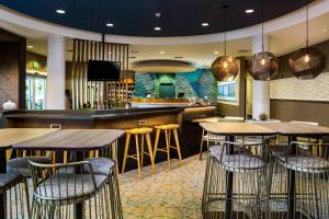 un bar con mesas de madera y taburetes en un restaurante en SpringHill Suites Vero Beach, en Vero Beach