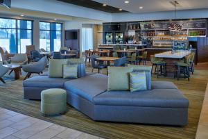 eine Lobby mit Sofas und Tischen sowie ein Restaurant in der Unterkunft Courtyard by Marriott Indianapolis Castleton in Indianapolis