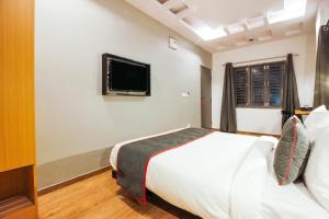 a bedroom with a bed and a tv on the wall at Townhouse RCC Sunrise in Ameerpet