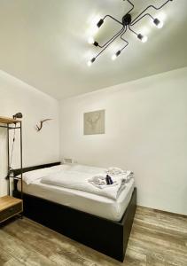 Habitación blanca con cama y lámpara de araña. en Life Studio & City Bike, en Bolzano