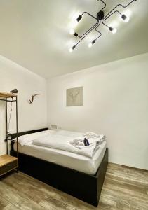 a white bedroom with a bed and a chandelier at Life Studio & City Bike in Bolzano