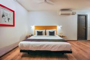 a bedroom with a large bed with a wooden headboard at Super Townhouse RCC Sunrise in Hyderabad +44 photos