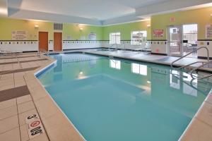a large swimming pool with blue water in a building at Fairfield Inn & Suites by Marriott Grand Island in Grand Island