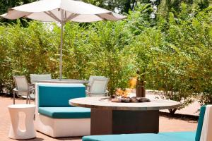 eine Terrasse mit einem Tisch, Stühlen und einem Sonnenschirm in der Unterkunft SpringHill Suites by Marriott Philadelphia Langhorne in Langhorne