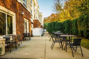 eine Reihe von Tischen und Stühlen außerhalb eines Gebäudes in der Unterkunft Fairfield by Marriott Medford Long Island in Medford