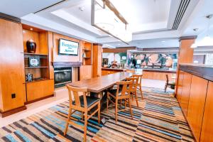 uma sala de jantar com uma mesa de madeira e cadeiras em Fairfield by Marriott Medford Long Island em Medford