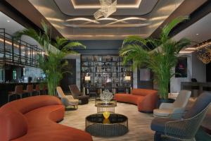 a lobby with orange furniture and palm trees at Izmir Marriott Hotel in İzmir