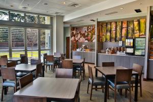 a restaurant with tables and chairs and a bar at Fairfield Inn & Suites by Marriott Savannah Midtown in Savannah