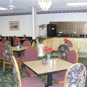 un comedor con mesas y sillas con flores. en Royal Inn en Alcoa