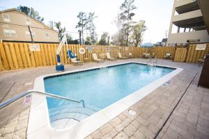 a swimming pool with chairs and a fence at Fairfield Inn & Suites by Marriott Savannah Midtown in Savannah