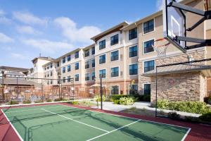 una pista de tenis frente a un edificio con un aro de baloncesto en Residence Inn San Diego Oceanside en Oceanside