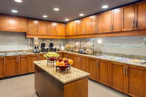 una cocina con armarios de madera y un bol de fruta en una barra en Residence Inn San Diego Oceanside en Oceanside