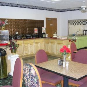 a room with a table and chairs and a kitchen at Royal Inn in Alcoa