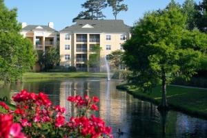 a building with a pond in front of a building at Sheraton Broadway Resort Villas in Myrtle Beach