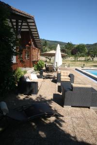 un patio con sillas, una sombrilla y una piscina en Chalet con piscina en Peón "Los Tres Robles", 