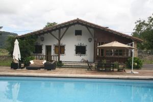 una casa con piscina frente a ella en Chalet con piscina en Peón "Los Tres Robles", 