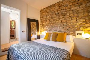 a bedroom with a bed and a stone wall at Can Font in Santa Eularia des Riu