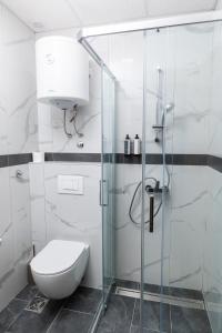 a bathroom with a toilet and a glass shower at Garni Hotel IMPERIUM Subotica in Subotica