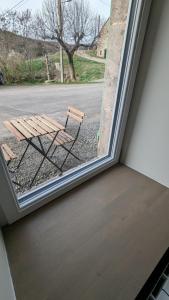 drewniana ławka siedząca na zewnątrz okna w obiekcie La Couze Pavin w mieście Saint-Diéry