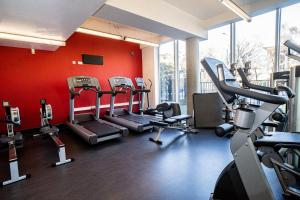 a gym with cardio equipment and a red wall at Davies Court (Canary Wharf) in London