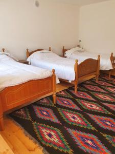 three beds in a room with a rug on the floor at Sebishti Guesthouse 
