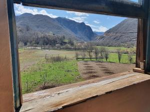 a window with a view of a field and mountains at Sebishti Guesthouse 
