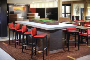 a bar with red stools in a restaurant at Courtyard by Marriott Houston Hobby Airport in Houston