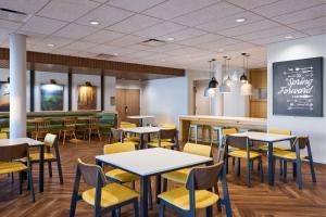 a restaurant with tables and yellow chairs and a counter at Fairfield by Marriott Inn & Suites Hagerstown in Hagerstown