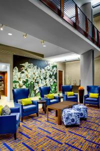 a lobby with blue chairs and tables and a mural at Courtyard by Marriott Atlanta Buckhead in Atlanta