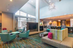 a hotel lobby with a large tv and chairs at Residence Inn by Marriott Denton in Denton