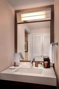 a bathroom with a sink and a large mirror at Courtyard Parsippany in Parsippany
