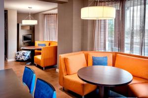 a waiting room with orange chairs and tables at Courtyard Parsippany in Parsippany