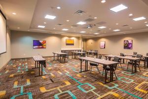 a conference room with tables and chairs on a rug at Residence Inn by Marriott Denton in Denton