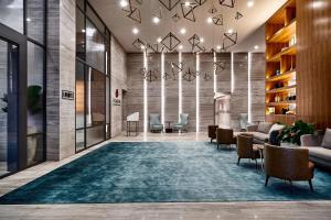 a lobby with couches and chairs and a rug at Sheraton Santos Hotel in Santos